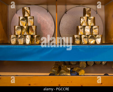 Aim and win with a ball on a pyramid of golden metal cans Stock Photo