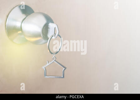 House shape key chain hanging on door knob. concept of buying new house and home safety Stock Photo
