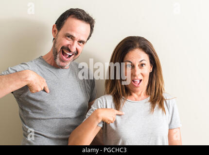 Middle age couple, woman and man with surprise face pointing finger to himself Stock Photo