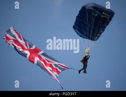 Dunsfold Park, Surrey, UK. 25 August, 2018. Weekend iconic aviation and motoring show at Dunsfold features flying displays and modern, classic & vintage supercars. Weather changes may curb may flying activities on Sunday 26 August as heavy rain is forecast. Photo: The Army Tigers, The Princess of Wales’s Royal Regiment’s Parachute Display Team perform. Credit: Malcolm Park/Alamy Live News. Stock Photo