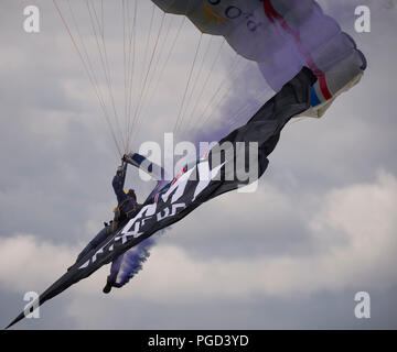 Dunsfold Park, Surrey, UK. 25 August, 2018. Weekend iconic aviation and motoring show at Dunsfold features flying displays and modern, classic & vintage supercars. Weather changes may curb may flying activities on Sunday 26 August as heavy rain is forecast. Photo: The Army Tigers, The Princess of Wales’s Royal Regiment’s Parachute Display Team perform. Credit: Malcolm Park/Alamy Live News. Stock Photo