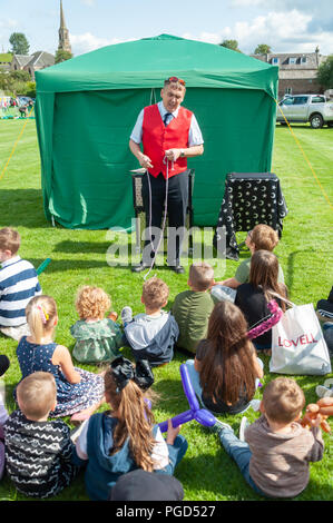 Strathaven, Scotland, UK. 25th August, 2018. A magician entertaining the kids at the Strathaven Balloon Festival celebrating its 20th Anniversary and is held in the award winning John Hastie Park. Credit: Skully/Alamy Live News Stock Photo