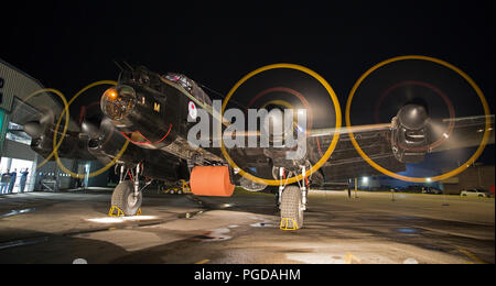 Nanton, Canada. 24th August, 2018.  Lancaster Bomber with a full-size, steel bouncing bomb spinning in the bomb-bay is started up during a night engine run at the Bomber Command Museum of Canada. The event is part of a 75th anniversary commemoration of the Dambusters Raid during World War II. Rosanne Tackaberry/Alamy Live News Stock Photo