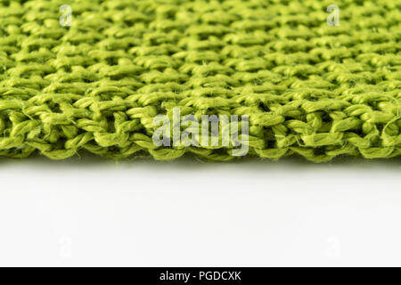 Wool blanket, green, knitted large chunky yarn. Close-up of knitted blanket on white background. Stock Photo