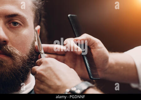 Barbershop with wooden interior. Bearded model man and barber. Stock Photo