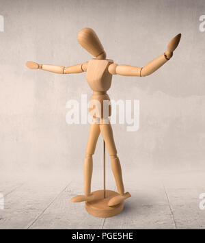 Wooden mannequin posed in front of a greyish background Stock Photo