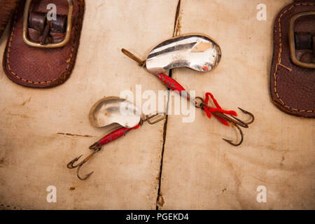Two metal lures known as kidney spoons due to their shape with treble hooks  displayed on an old fishing tackle bag. From a collection of vintage fishi  Stock Photo - Alamy