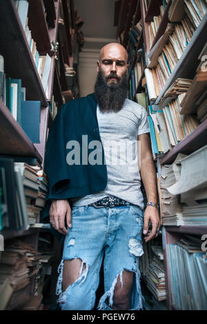 Portrait of bearded alone hipster man in library. depression Stock Photo