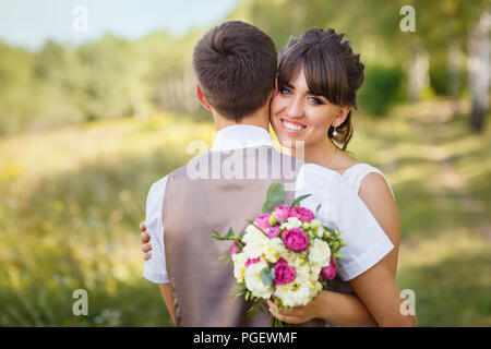 groom hugs the bride at wedding day outdoors Stock Photo