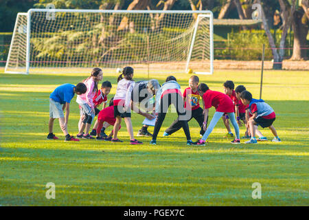 CHIANG MAI, THAILAND - 29 January 2018 - School kids strech their legs with their coach before playing sport at school soccer field in Chiang Mai, Tha Stock Photo