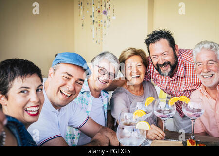 mixed ages group of caucasian people having fun together celebrating an event drinking cocktail with red wine of white vodka. holiday concept with hap Stock Photo
