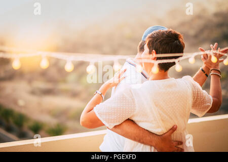 beautiful couple dancing on the terrace rooftop with natural view. love and dating concept for people having romantic leisure activity together with l Stock Photo