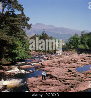 1960s, killin, scotland, people on the rocks at the falls of dochart. Stock Photo