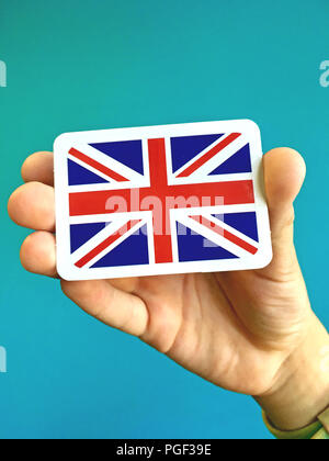 Small card of national flag of Great Britain in the hand Stock Photo