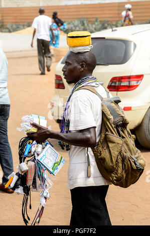 LOME, TOGO - Jan 9, 2017: Unidentified Togolese man carries accessories for the cellphone at the Lome port. Togo people suffer of poverty due to the b Stock Photo