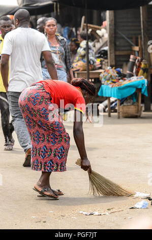 LOME, TOGO - Jan 9, 2017: Unidentified Togolese woman sweeps the ground at the Lome port. Togo people suffer of poverty due to the bad economy Stock Photo