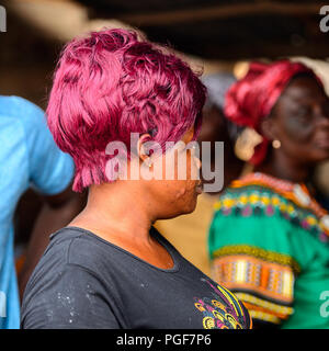 LOME, TOGO - Jan 9, 2017: Unidentified Togolese woman with pink hair at the Lome port. Togo people suffer of poverty due to the bad economy Stock Photo