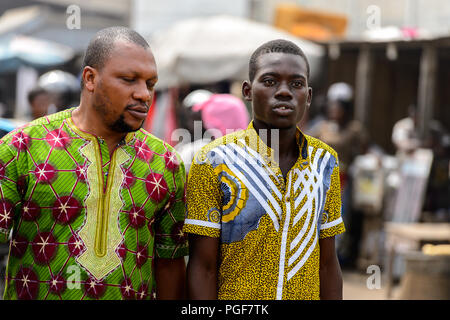 LOME, TOGO - Jan 9, 2017: Unidentified Togolese two men  walk at the Lome port. Togo people suffer of poverty due to the bad economy Stock Photo