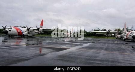 Air Station Barbers Point HC-130 Hercules aircraft await tasking in response to Hurricane Lane at Hilo International Airport, Hawaii, Aug. 24, 2018. The Coast Guard was working closely with federal, state and local authorities to prepare for Hurricane Lane. (U.S. Coast Guard photo by Chief Petty Officer Billy Mapakoi/Released) Stock Photo