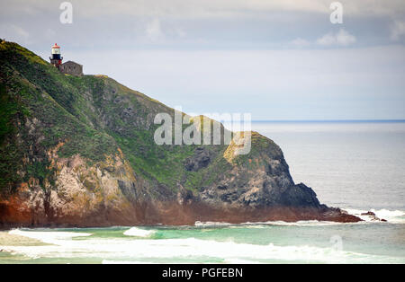 Monterey, California: Colourful scene, Point Sur Lighthouse atop a dramatic volcanic rock with hazy sea/sky background Stock Photo