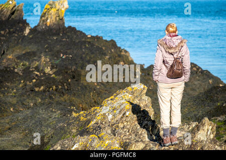 Lady observing the sea at Bull Bay on Anglesey, Wales - UK Stock Photo