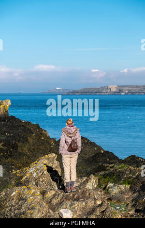 Lady observing the sea at Bull Bay on Anglesey, Wales - UK Stock Photo