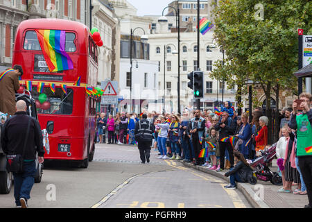 Hastings, East Sussex, UK. 26th Aug, 2018. Hastings pride and festival parade celebrates diversity in this seaside town on the south east coast. This years theme is no discrimination, no alienation. The event runs from 11am until late in the evening. Old london red bus with rainbow flag drives through the high st with crowds of people on the pavement cheering. © Paul Lawrenson 2018, Photo Credit: Paul Lawrenson / Alamy Live News Stock Photo
