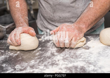 Baker hands kneading bread dough Stock Photo