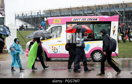 Crowds shelter from the rain as the the GoPro British Grand Prix MotoGP is delayed at Silverstone, Towcester. Stock Photo