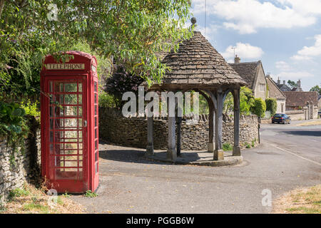 The water pump, shelter and red telephone box, Biddestone village, Wiltshire, England, UK Stock Photo