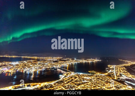 Incredible Northern lights Aurora Borealis activity above town of Tromso in Northern Norway Stock Photo