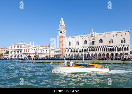 Ride on a water taxi in St marks Basin, Venice, Veneto, Italy passing Doges Palace and Campanile, Riva degli Schiavoni,  in early morning light Stock Photo