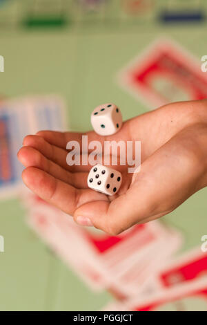 The hand throws game dice on the background of the playing field Stock Photo