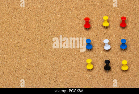 Nine colored pinned button on a cork board Stock Photo