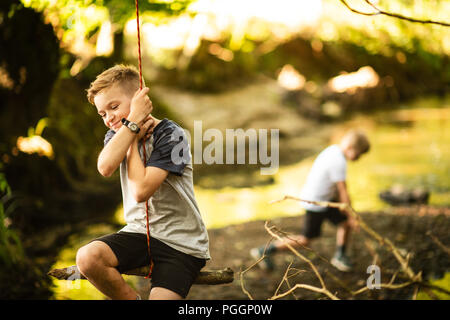 Boy swinging on rope swing Stock Photo