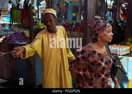 STONE TOWN, ZANZIBAR, TANZANIA - JULY 06 2008: A vendor reaches for a knife at a market in Stone Town, Zanzibar. Stock Photo