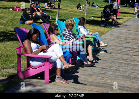 Toronto, Ontario, Canada-26 July, 2018: People enjoying scenic views of Ontario lake form the harbor promenade
