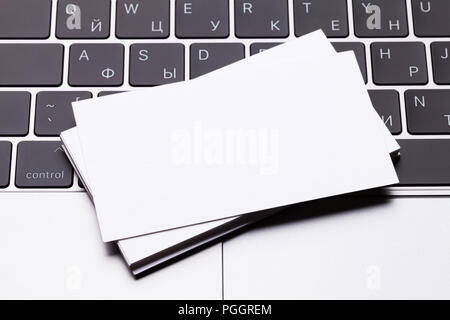 Blank business cards over laptop keyboard. Top view with space for your text Stock Photo