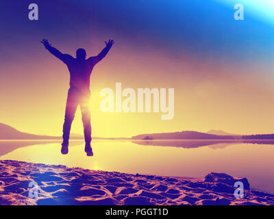 Sportsman doing stretching in the park. Silhouette against sun, sports concept.  Hipster filter. Stock Photo