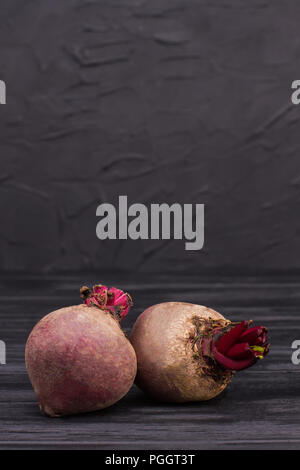 Two beetroots over black background. Raw fresh beetroots on dark wood. Stock Photo