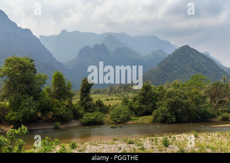 Scenic view of Nam Song River, fields and limestone mountains near Vang Vieng, Vientiane Province, Laos. Stock Photo