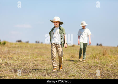 Kids brother and sister on African safari vacation walking in savanna Stock Photo