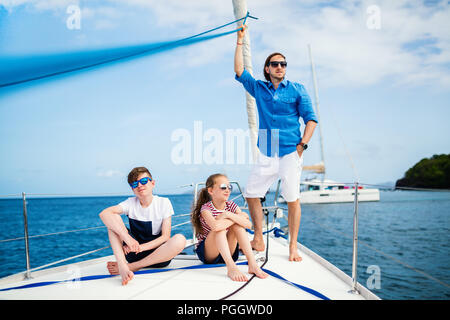 Family of father and kids on board of sailing yacht having summer travel adventure Stock Photo