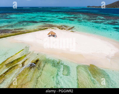 Aerial drone view of tiny tropical Mopion island sandbar, turquoise Caribbean sea and a family with kids in St Vincent and Grenadines Stock Photo