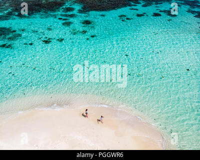Aerial drone view of tiny tropical Mopion island sandbar, turquoise Caribbean sea and a family with kids in St Vincent and Grenadines Stock Photo