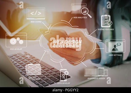 Developing programming and coding technologies with Website design in virtual diagram.Hands of businessman using mobile phone in modern office with la Stock Photo