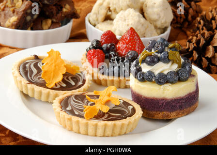 a plate of holiday dessert tarts with cookies and brownies Stock Photo