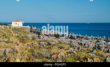 Unidentifiable tourists at popular rocky seaside spot known as Hell's Mouth or in Portuguese: Boca do Inferno, Cascais, Portugal Stock Photo