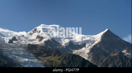 Dome and Aiguille du Gouter mountain peaks with the Bossons Glacier in the European Alps, a summer snowy landscape. Stock Photo