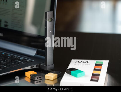 can you vape or smoke while pregnant Juul nicotine vapor dispenser charging in USB charger Stock Photo